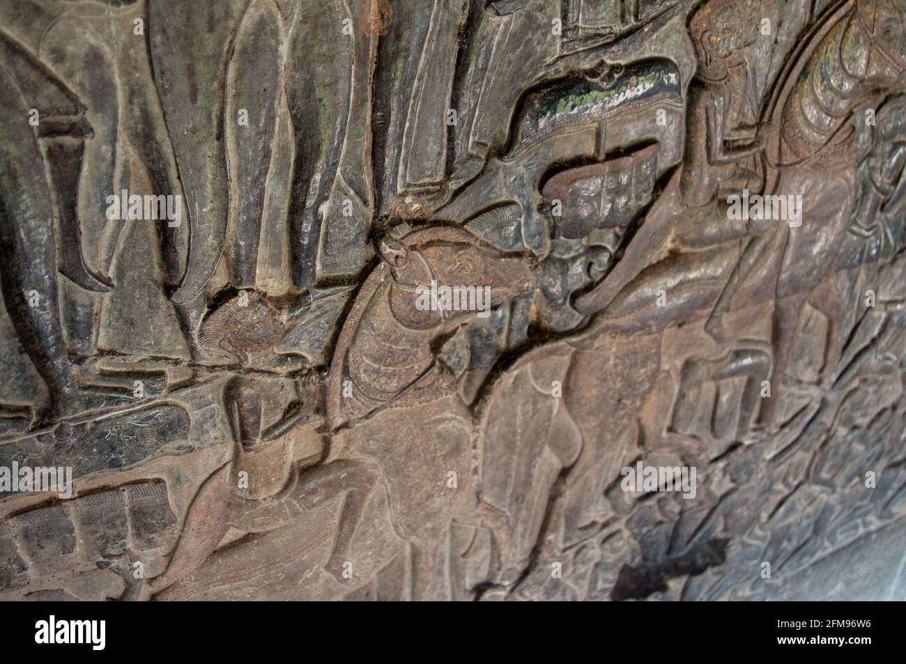 Carving of soldiers on horses dowing relief, Angkor Wat temple, Siem Riep, Cambodia Stock Photo