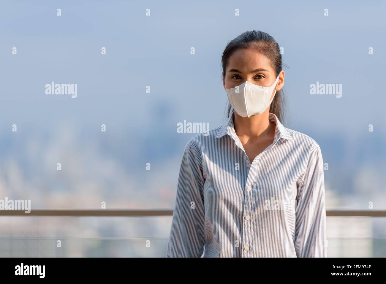Asian woman wearing face mask to protect from coronavirus Covid-19 horizontal shot Stock Photo