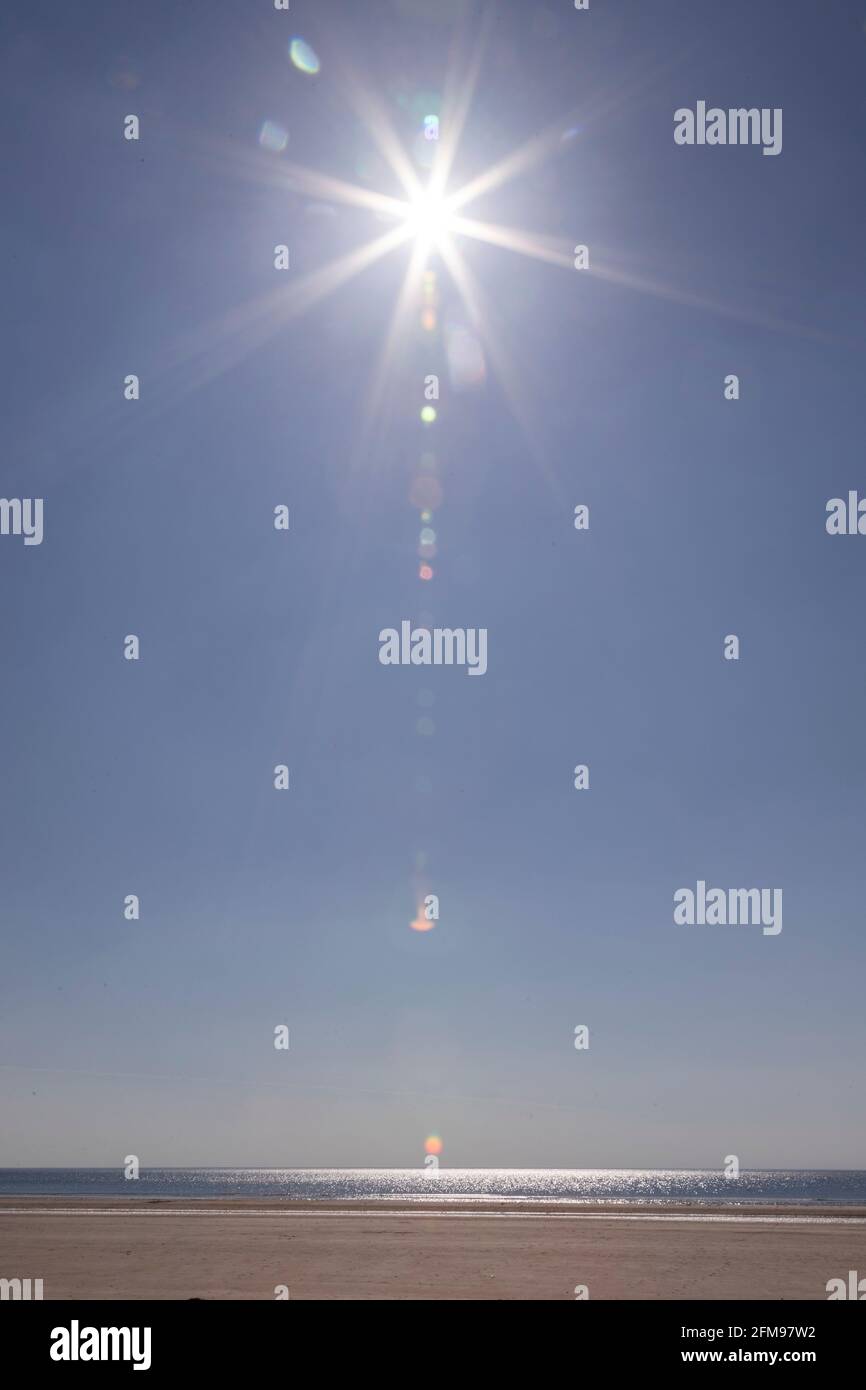 Sunstar over Harlech beach, Gwynedd, Wales Stock Photo