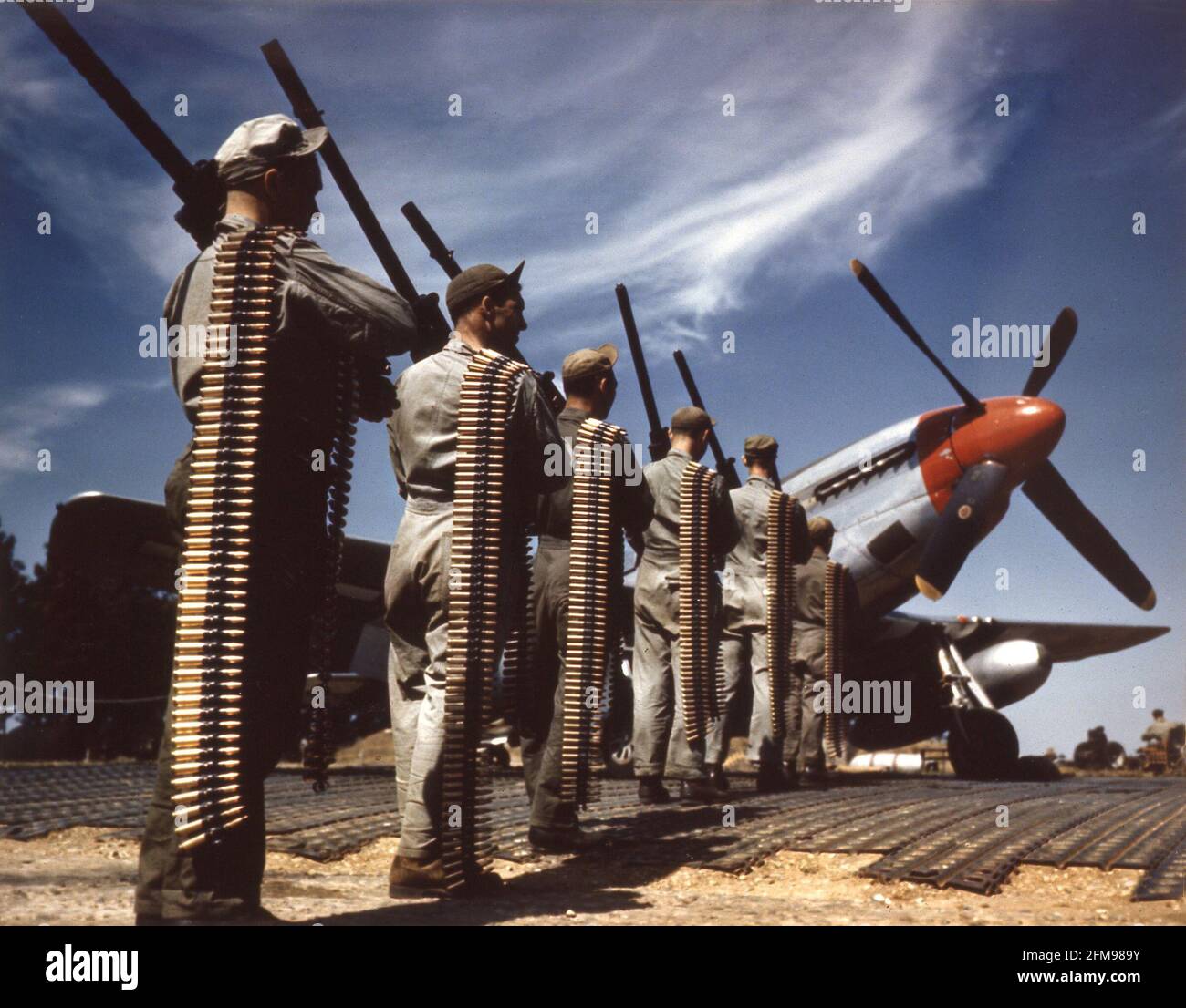 World War Two U.S. airmen line up to load ammunition in P-51 Mustang fighter warplane Stock Photo