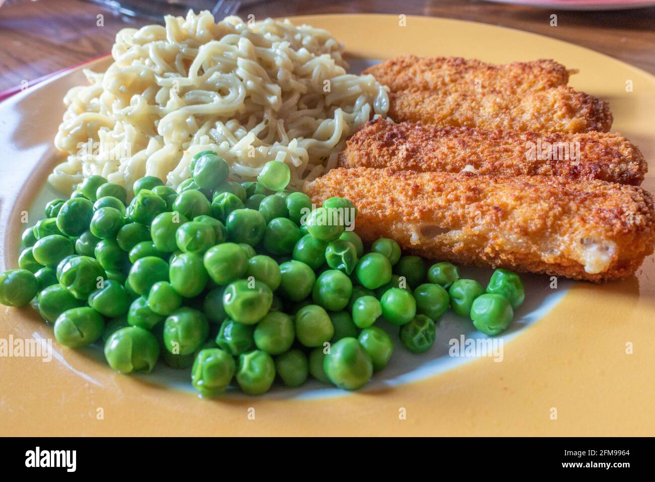 A quick and easy meal consisting of fish fingers, instant noodles and peas Stock Photo Alamy