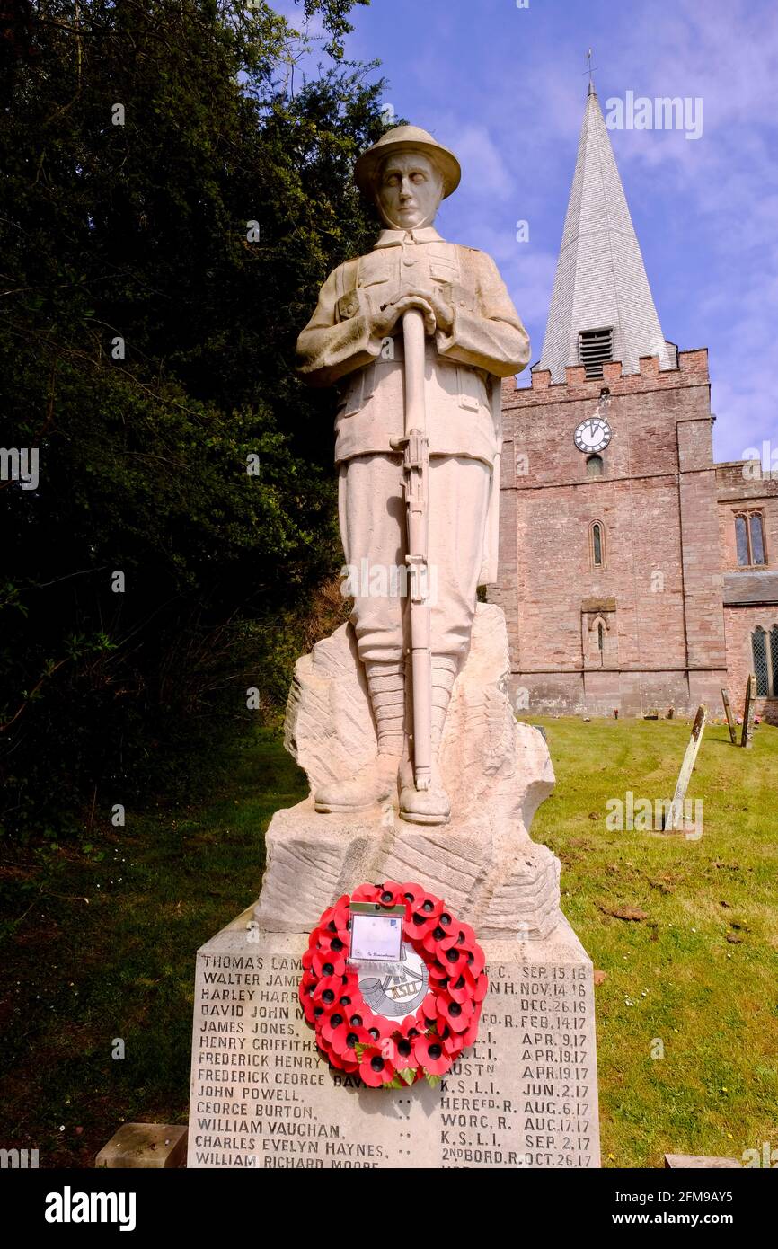 Remembrance in an English village church yard, statue of a British Tommy, soldier of the First World War. Poppy Wreath as an act of Remembrance. Stock Photo