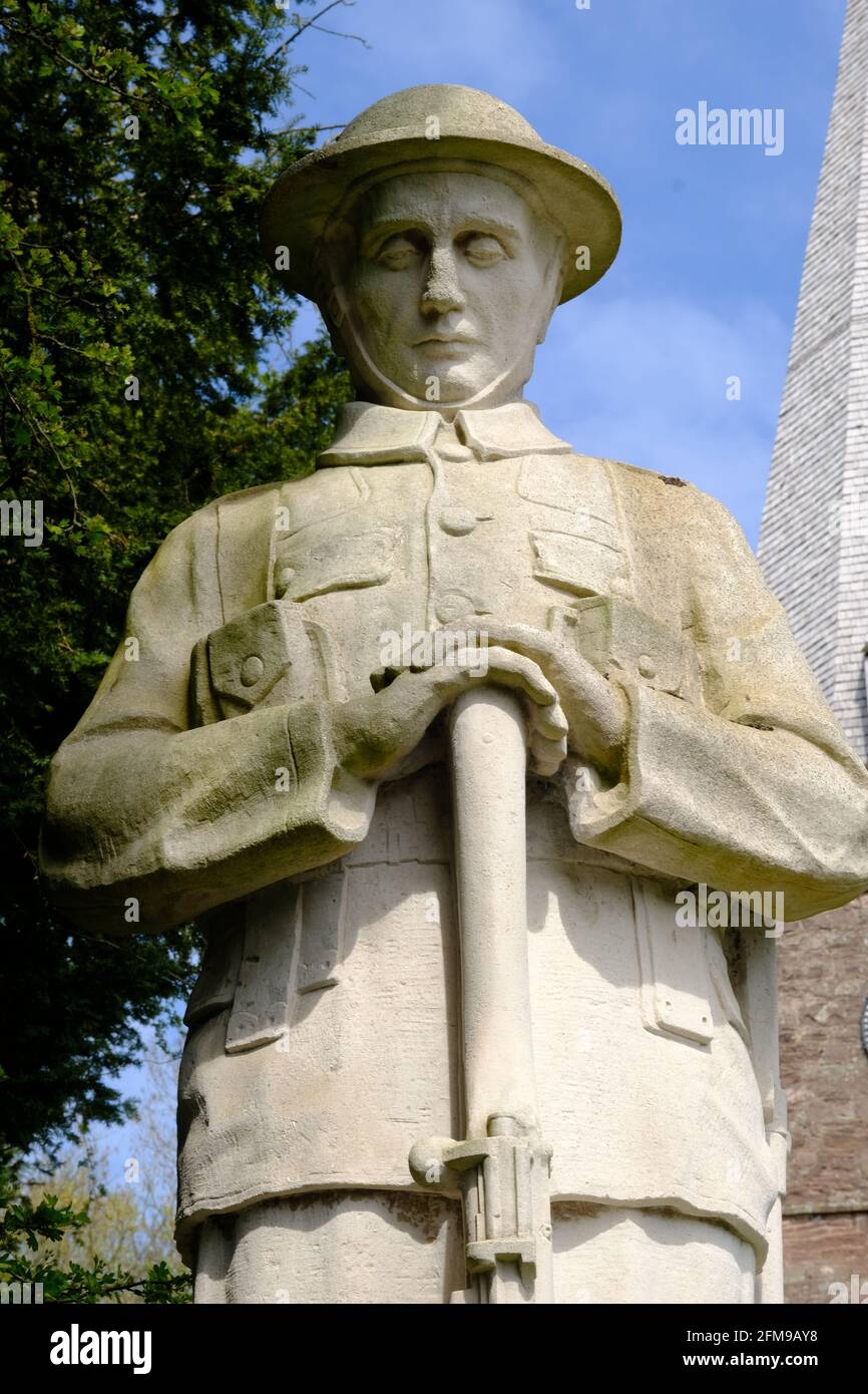 Remembrance in an English village church yard, statue of a British Tommy, soldier of the First World War. Poppy Wreath as an act of Remembrance. Stock Photo