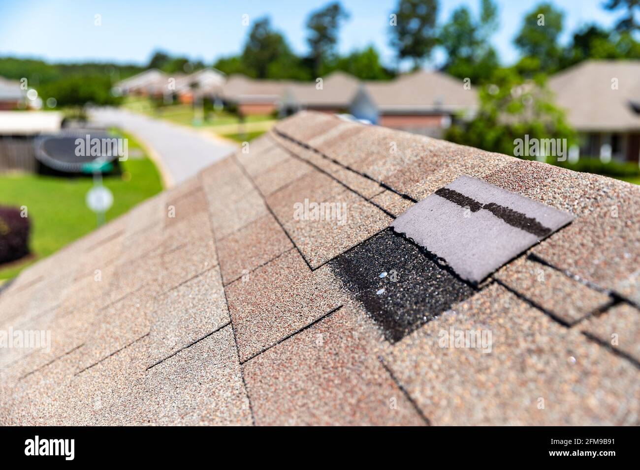 Missing shingles on roof due to storm damage. Stock Photo