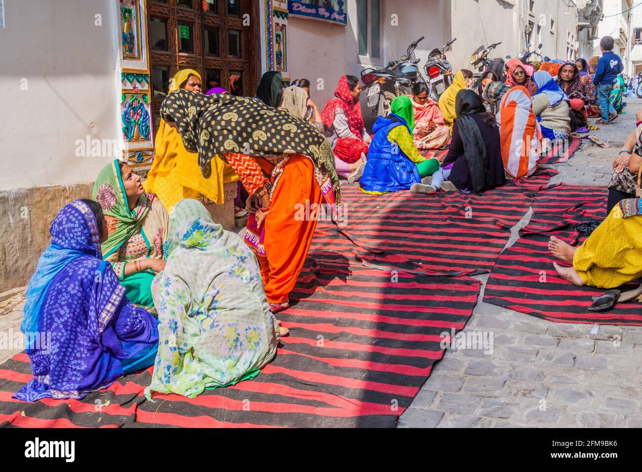 UDAIPUR, INDIA - FEBRUARY 12, 2017: Local women sitting in an alley in Udaipur, Rajasthan state, India Stock Photo