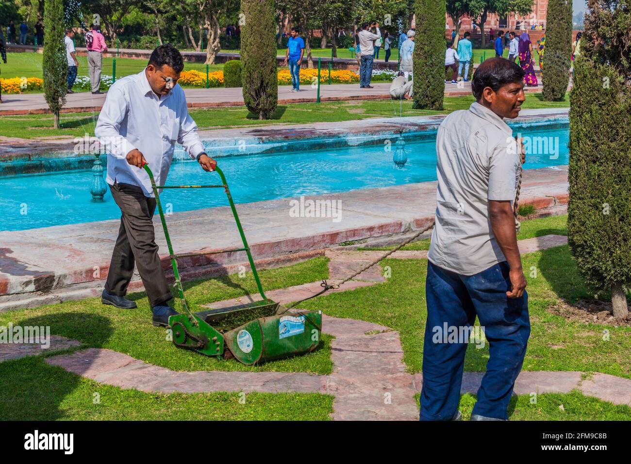 AGRA, INDIA - FEBRUARY 19, 2017: Workers are mowing a lawn Taj Mahal complex in Agra, India Stock Photo