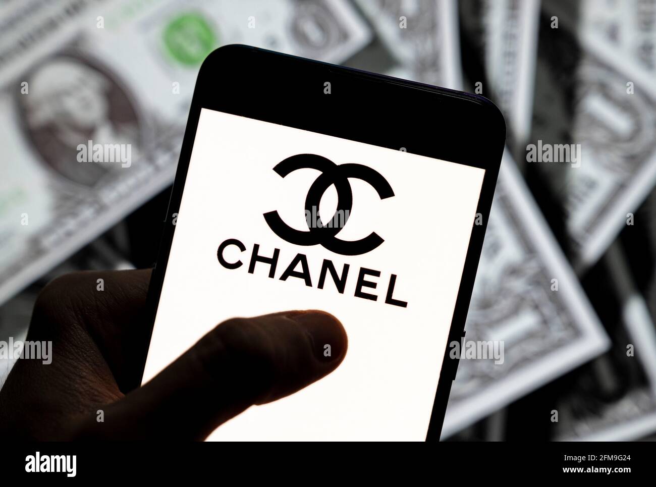 In this photo illustration the French multinational cosmetic beauty brand  Chanel logo seen displayed on a smartphone with USD (United States dollar)  currency in the background. (Photo by Budrul Chukrut / SOPA