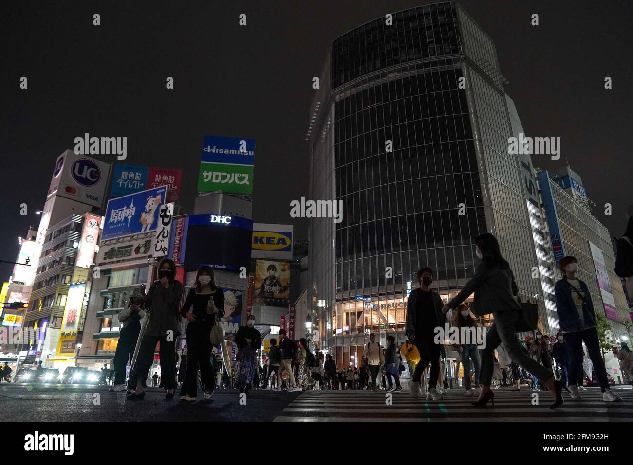 Tokyo, Japan. 7th May, 2021. Pedestrians cross a street at a popular nightlife area in Tokyo, Japan, May 7, 2021. Japanese Prime Minister Yoshihide Suga said on Friday the government is extending the state of emergency over COVID-19 in Tokyo, Osaka, Hyogo and Kyoto until the end of May, while expanding it to Aichi and Fukuoka prefectures. The emergency state was initially set to be eased next Tuesday. Credit: Christopher Jue/Xinhua/Alamy Live News Stock Photo