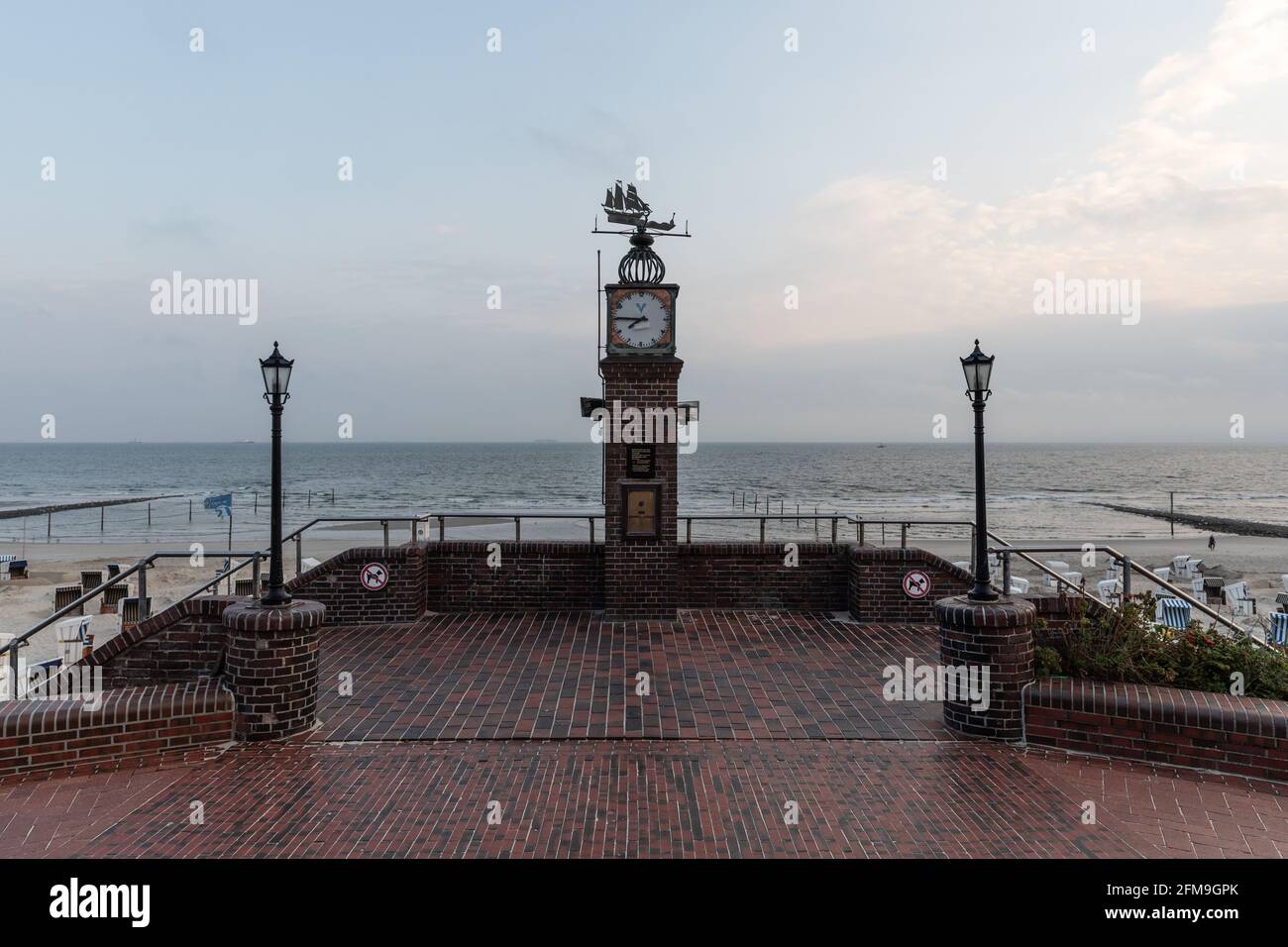 Landmark clock on the promenade on the North Sea beach of Wangerooge in the rain Stock Photo