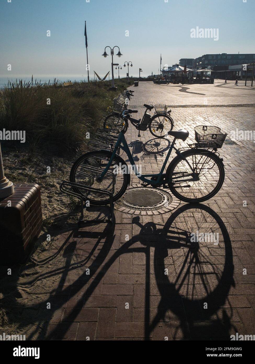 Bicycles on the waterfront in the backlight in the sunshine on the island of Wangerooge Stock Photo