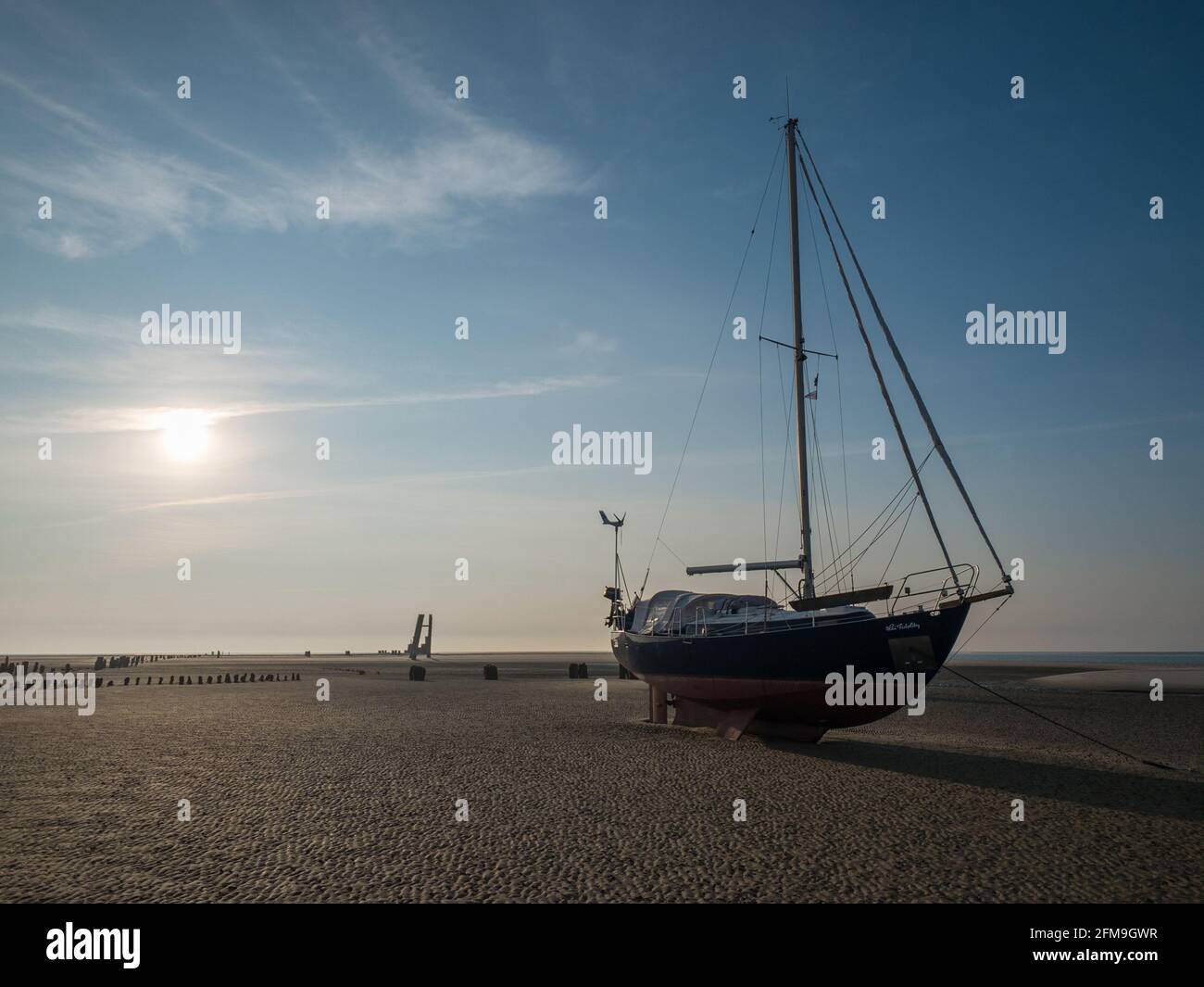 Sailboat at low tide on the east beach of Wangerooges Stock Photo