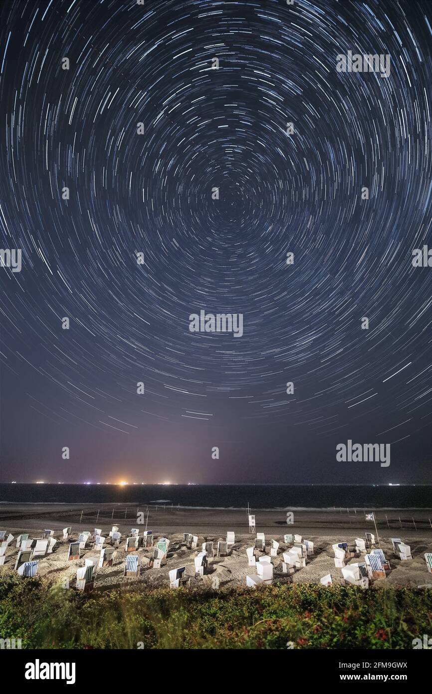 Startrails heading north over the North Sea on the island of Wangerooge at night Stock Photo