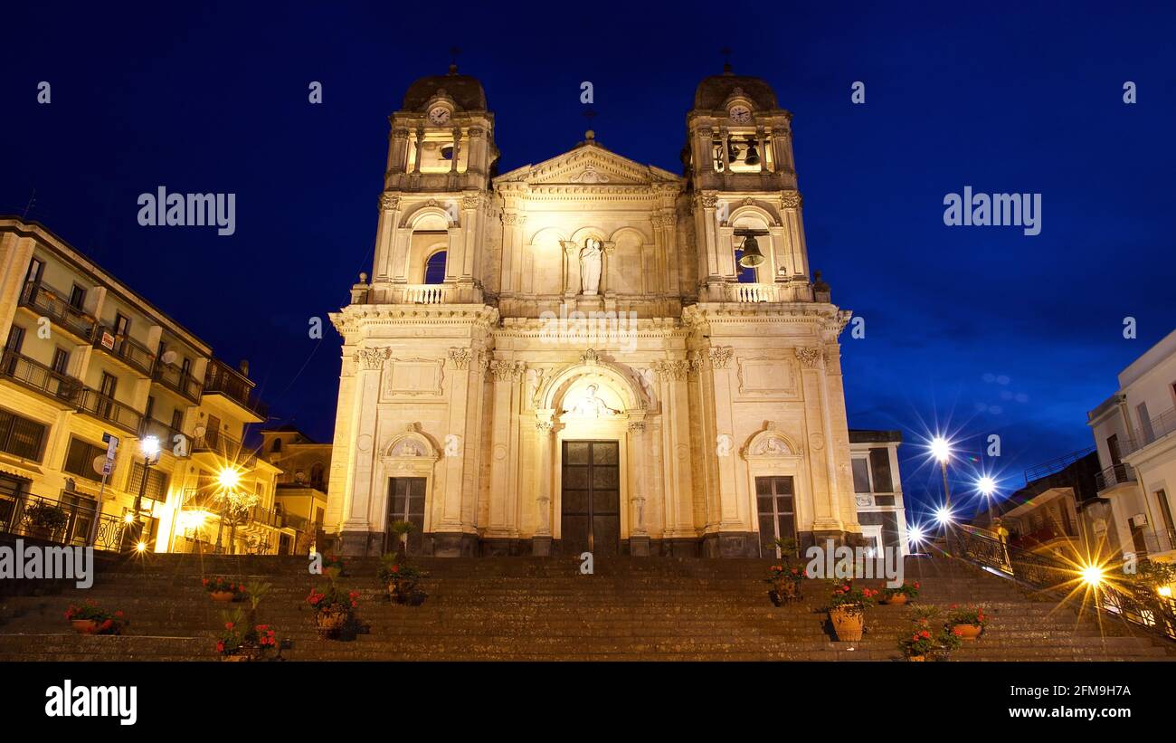 Italy, Sicily, Zafferana Etnea, town at the foot of Mount Etna, dawn, sky midnight blue, church Chiesa Madre di santa Maria della Provvidenza, super wide-angle shot, facade sloping from below, illuminated by artificial lamps, open staircase in the foreground Stock Photo