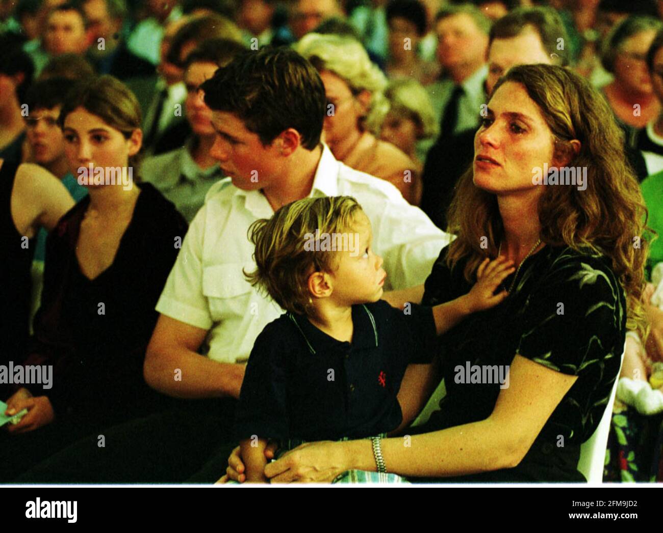 Zimbabwe Farmers Unrest April 2000 Memorial service to murdered white farmer David Stevens, in the Andy Millar hall Harare Zimbabwe.David Steven's widow, Maria with her son (one of the twins)Sebastian (2) on her lap son Mark (16) next to her, and daughter Brenda (14) next to him 25.4.00   Pic:JOHN VOOS Stock Photo