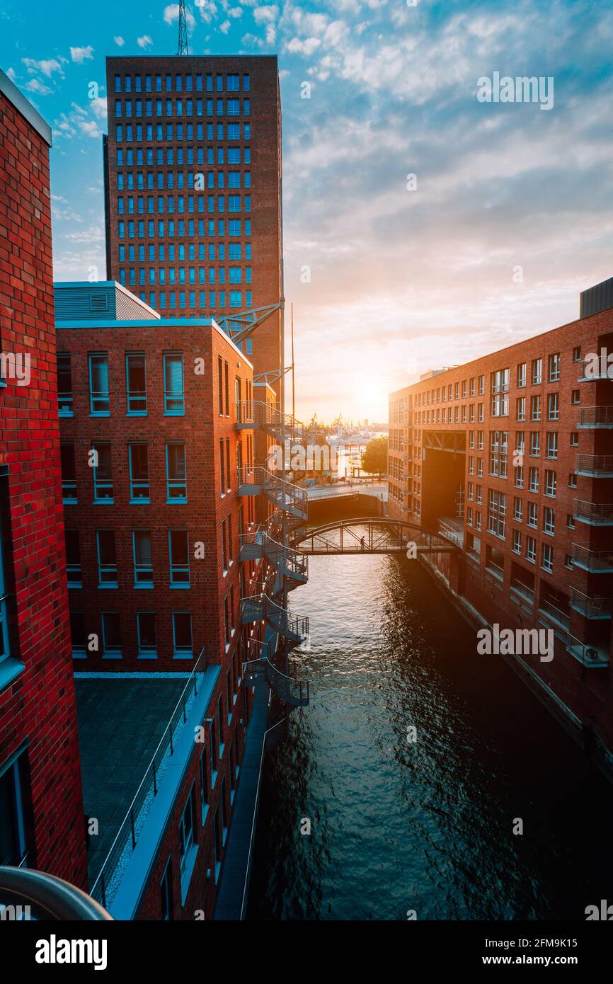 HafenCity. Bridge over canal and red brick buildings in the old warehouse district Speicherstadt in Hamburg in golden hour sunset light, Germany. View from above. Stock Photo