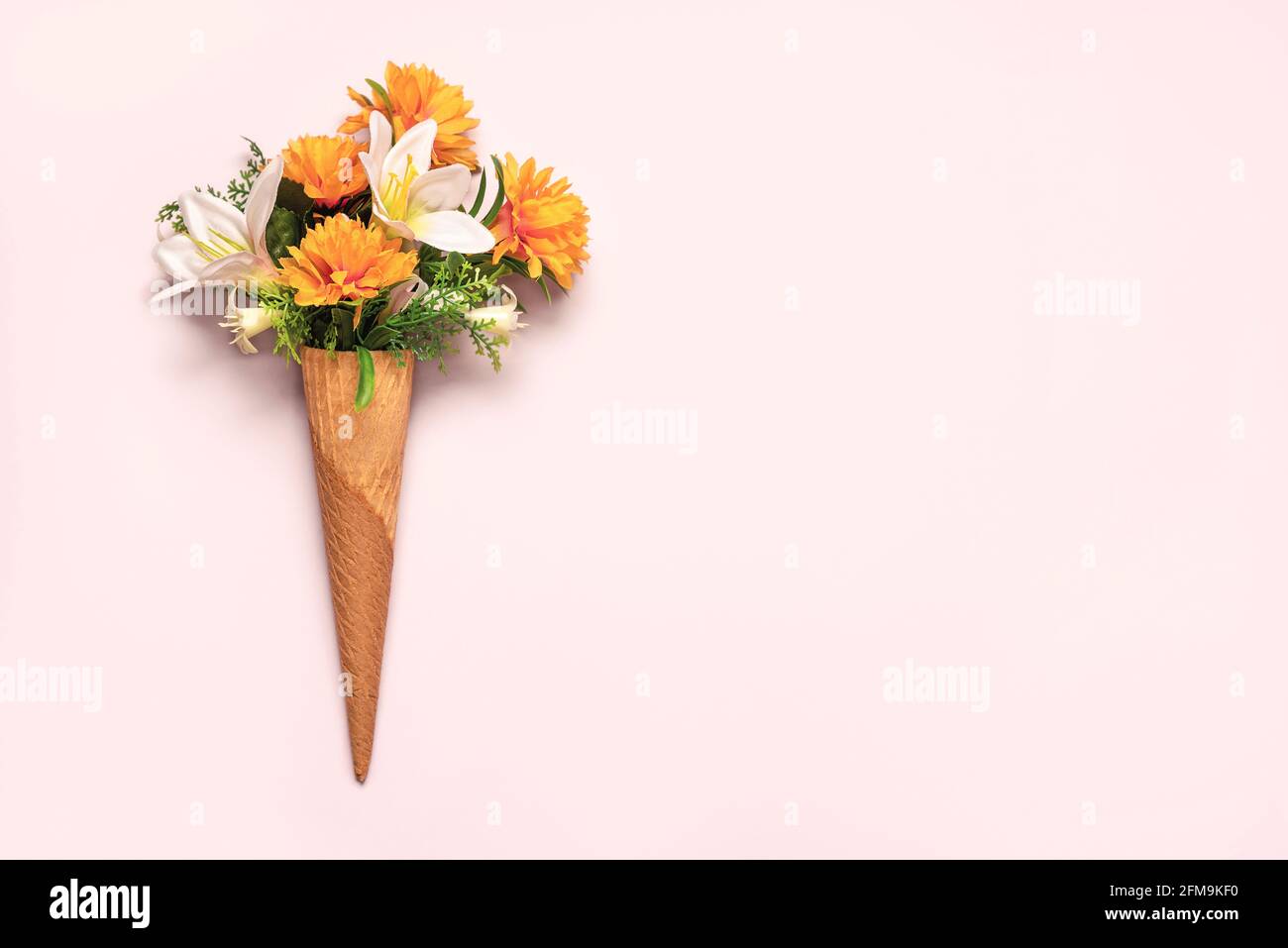 ice cream cone with flowers with copy space on a pink background Stock