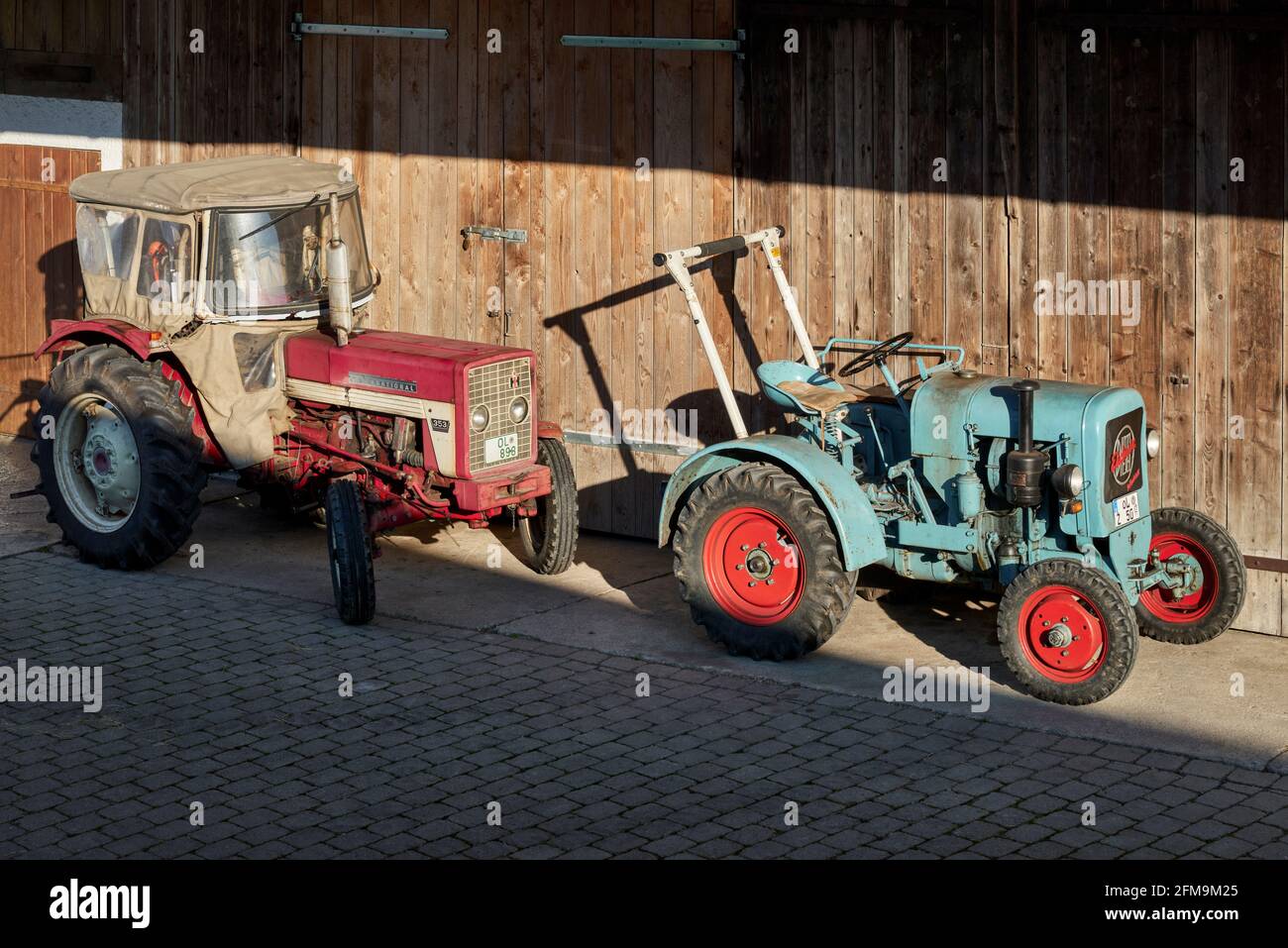 Eicher Diesel tractor and IHC 353 McCormick (International) in front of the barn Stock Photo