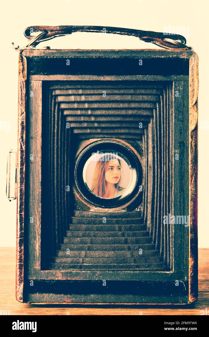 image of a young woman inside an old view camera back side Stock Photo