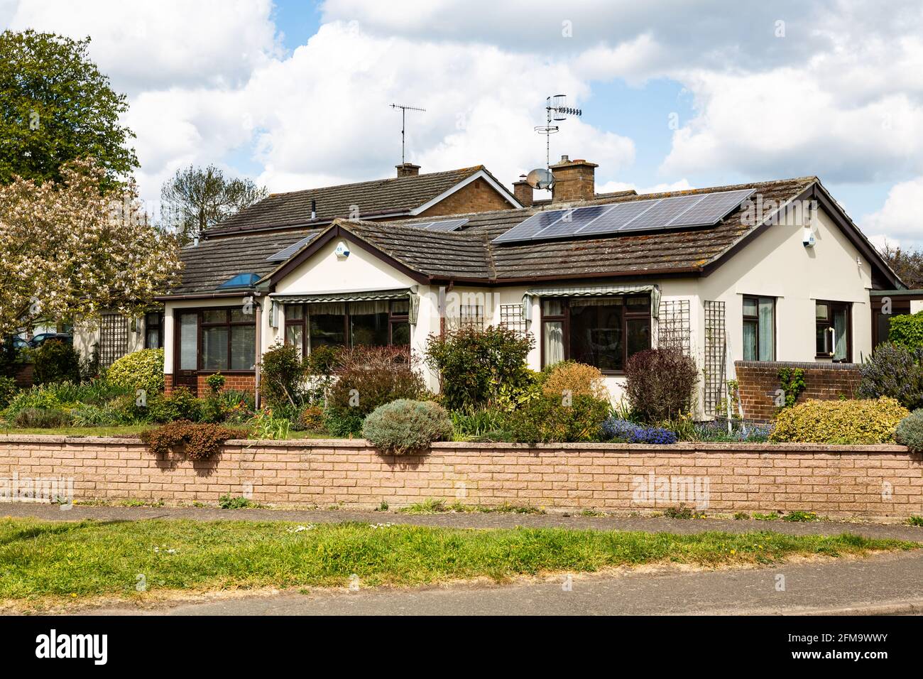 Woodbridge, Suffolk, UK April 30 2021: A small traditional bungalow with solar panels on the roof. Green energy solar energy Stock Photo