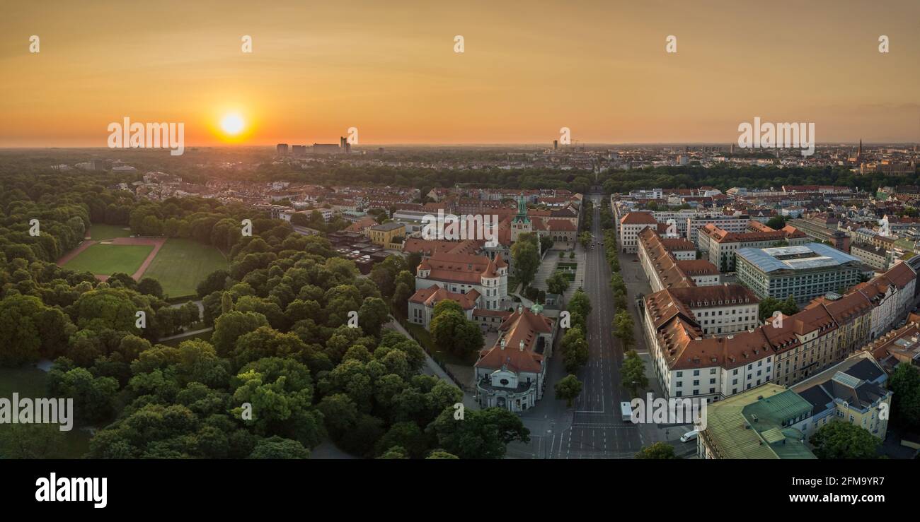The wonderful view at Munich in bavaria from a drone, an panoramic aerial over a park, houses at the early summer sunrise in the center of the bavarian capital Stock Photo