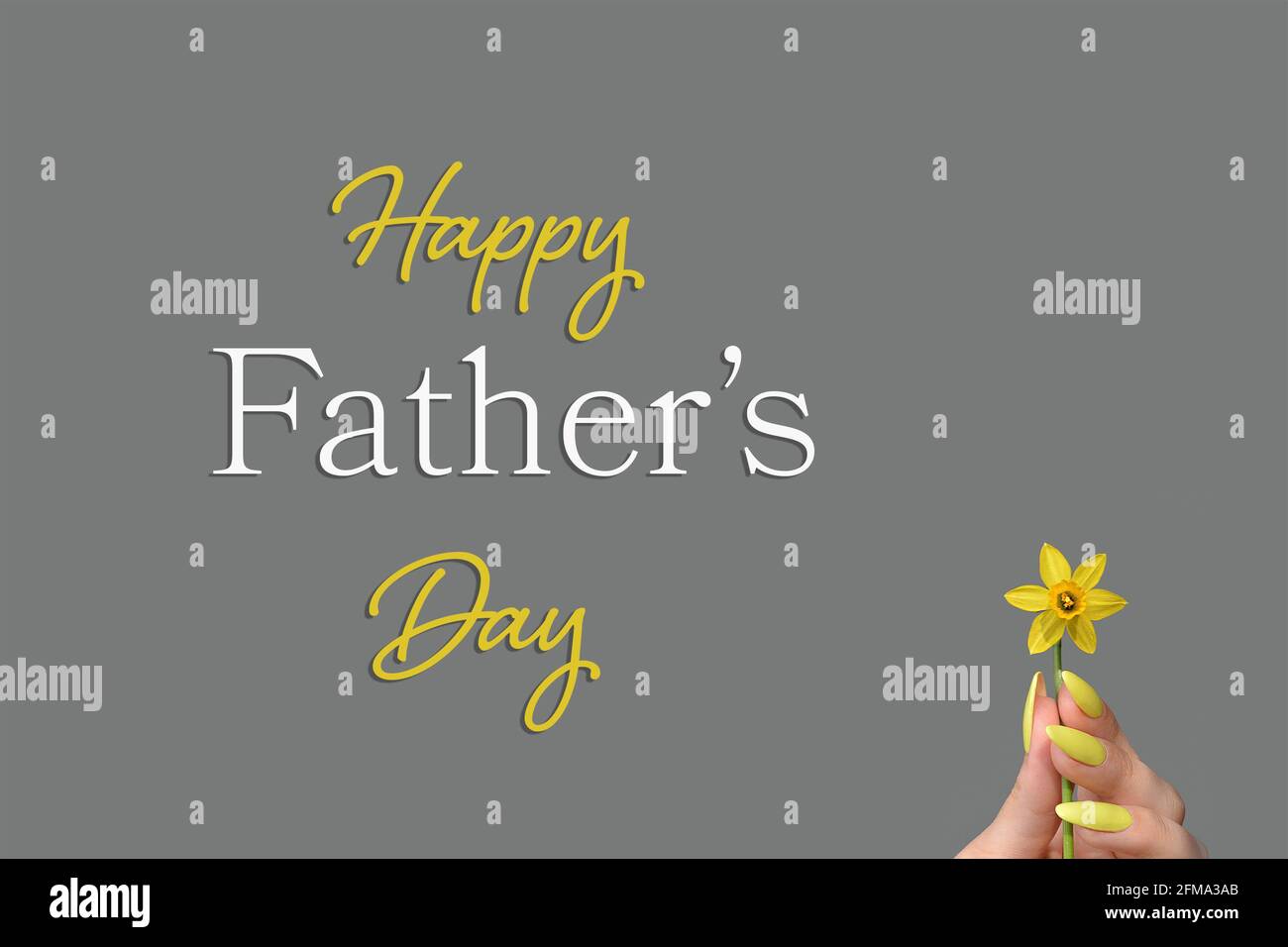 Fathers Day card with female hand holding daffodil flower Stock Photo