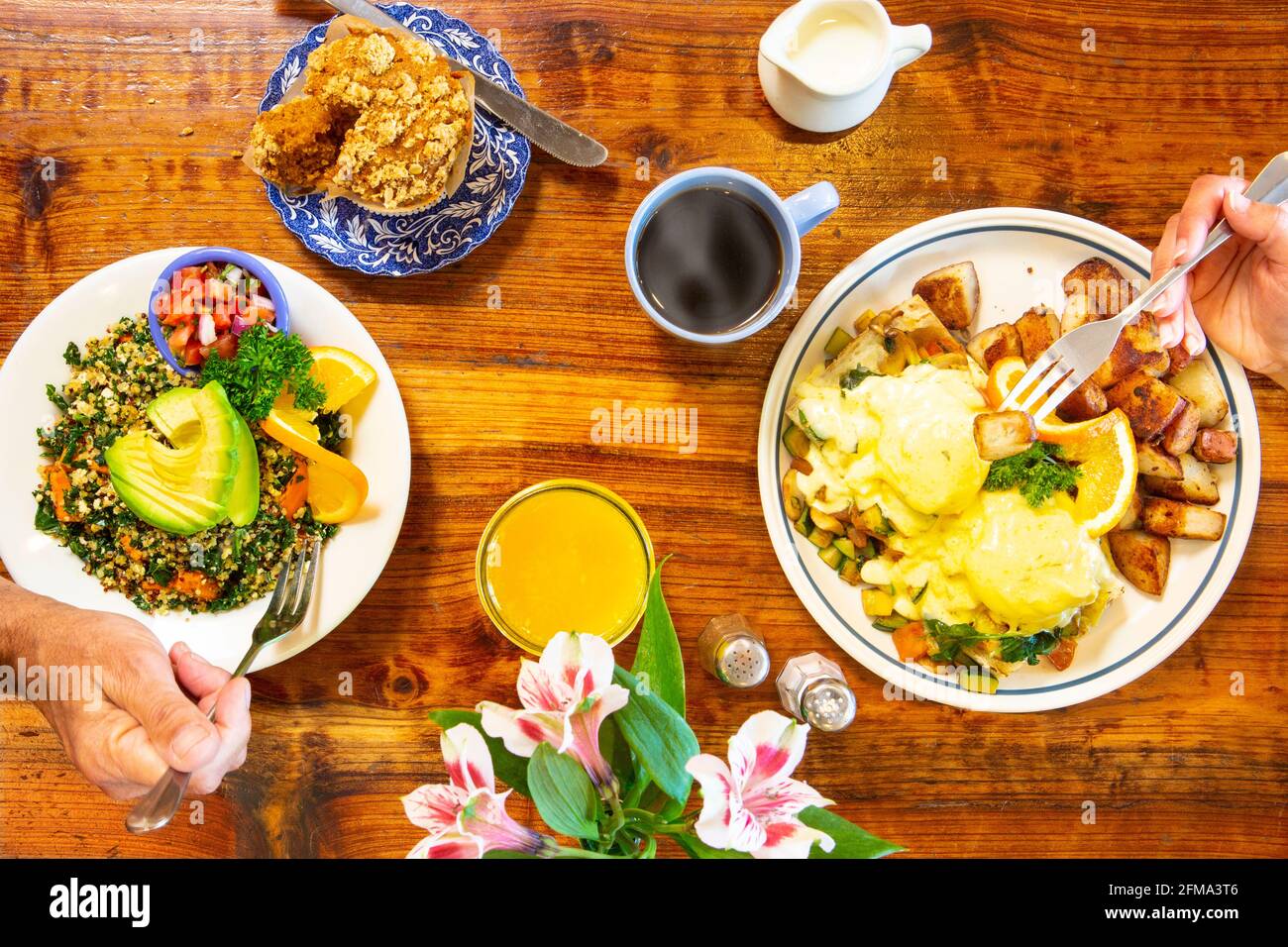 vegetarian eggs Benedict and a vegan scramble are enjoyed by two freiends Stock Photo