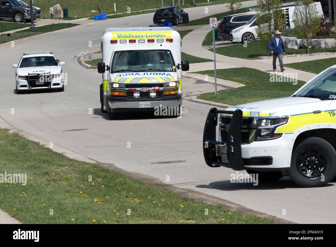 Emergency vehicles, police and ambulance (London EMS) block a roadway responding to a call in London, Ontario, Canada. Stock Photo