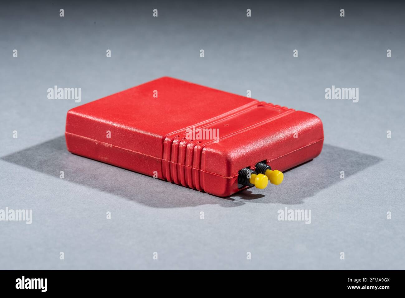 Data cartridge for a 1980s computer. Red with two yellow buttons. Stock Photo