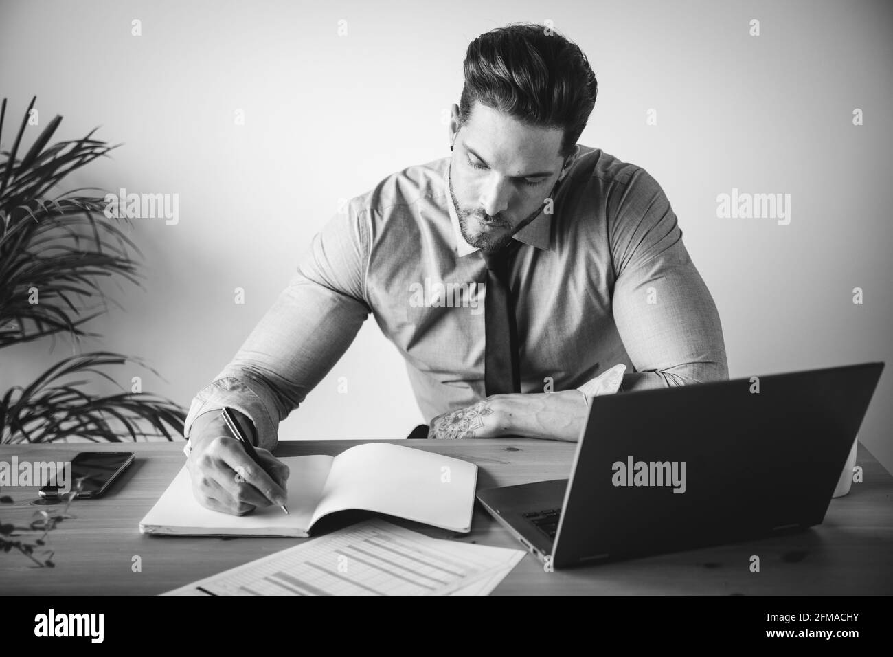 Young man sitting desk working Black and White Stock Photos & Images ...