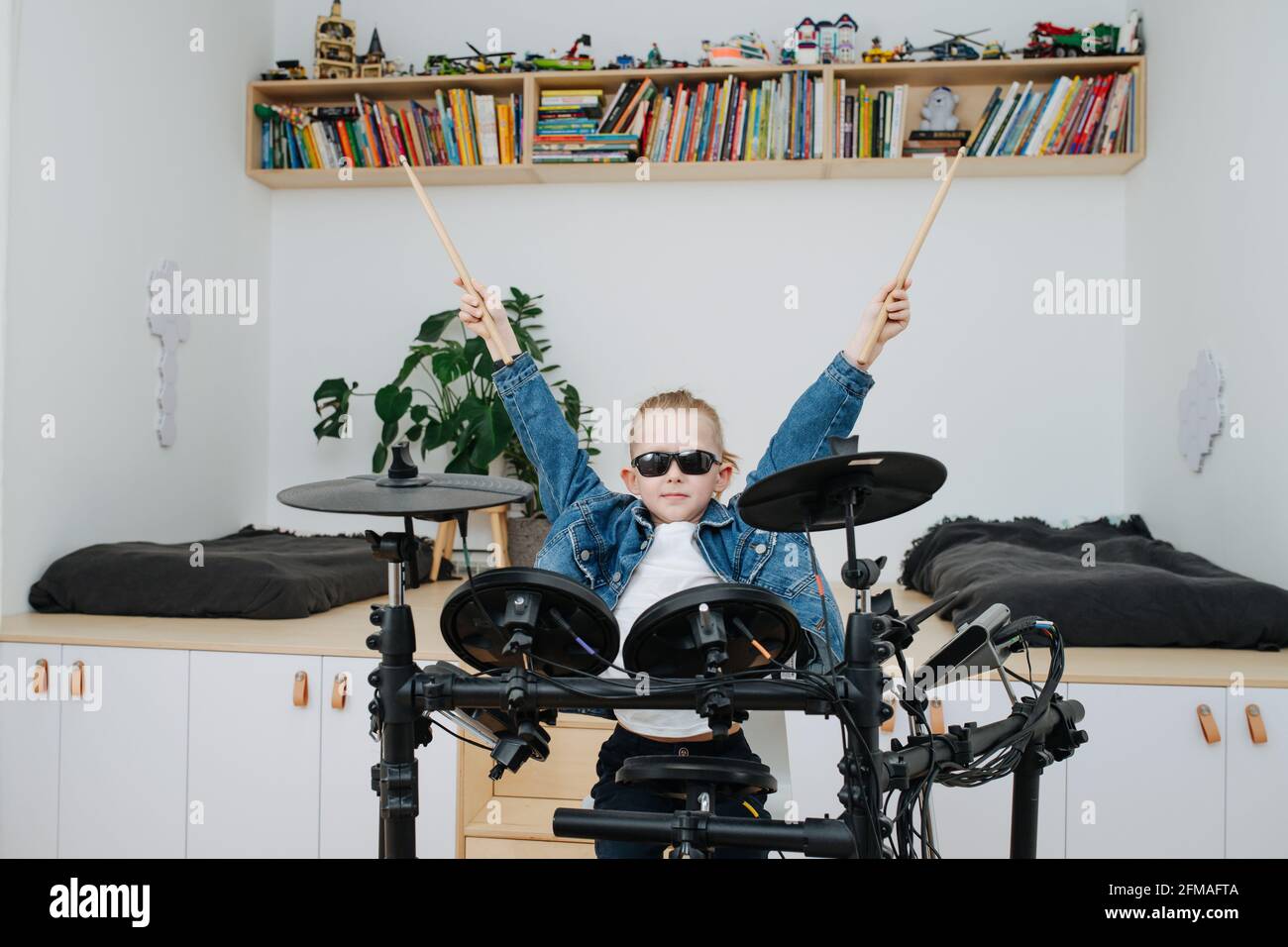 Little boy superstar in sunglasses playing electronic drums at home. He is  wearing jeans jacket, lifting his drumsticks up, imaging himself to be a po  Stock Photo - Alamy