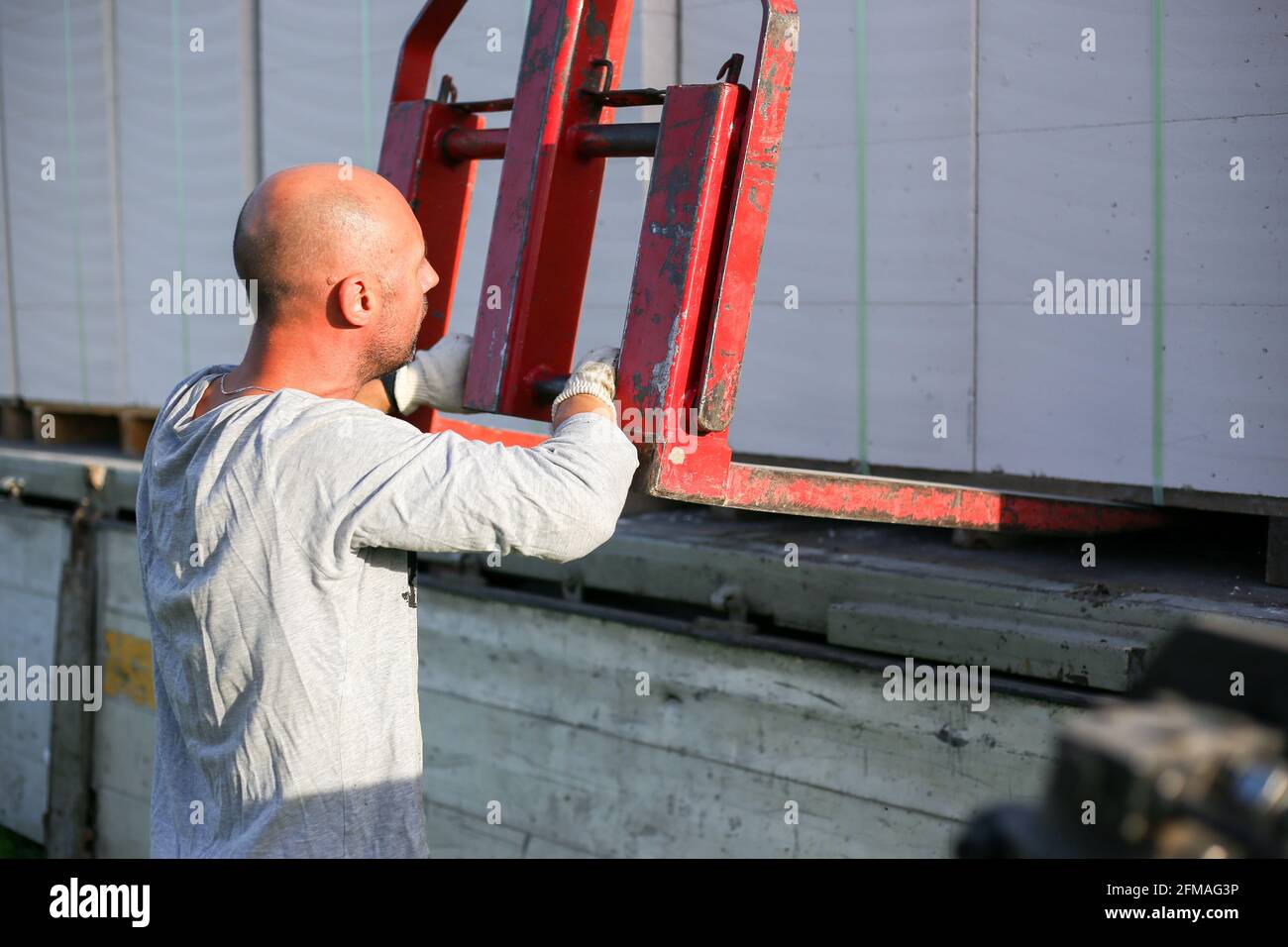 Unloading building blocks from a truck using a crane. Hydraulic ...
