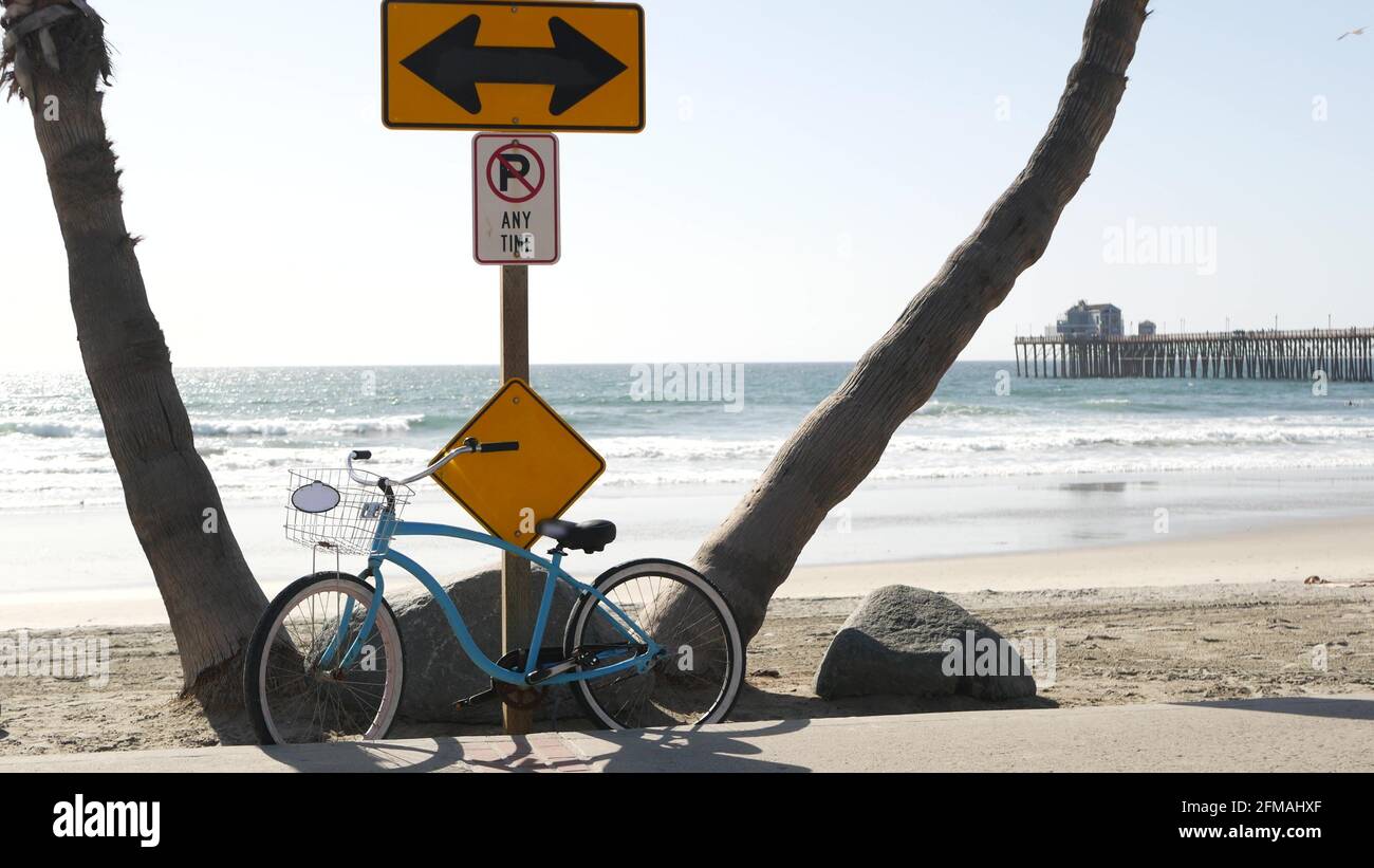 Blue bicycle, cruiser bike by sandy ocean beach, empty pacific coast