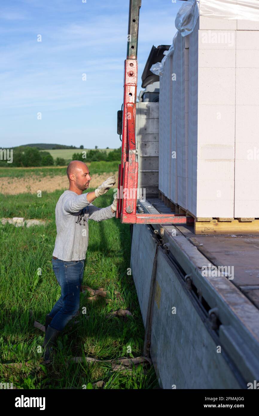 Unloading building blocks from a truck using a crane. Hydraulic ...