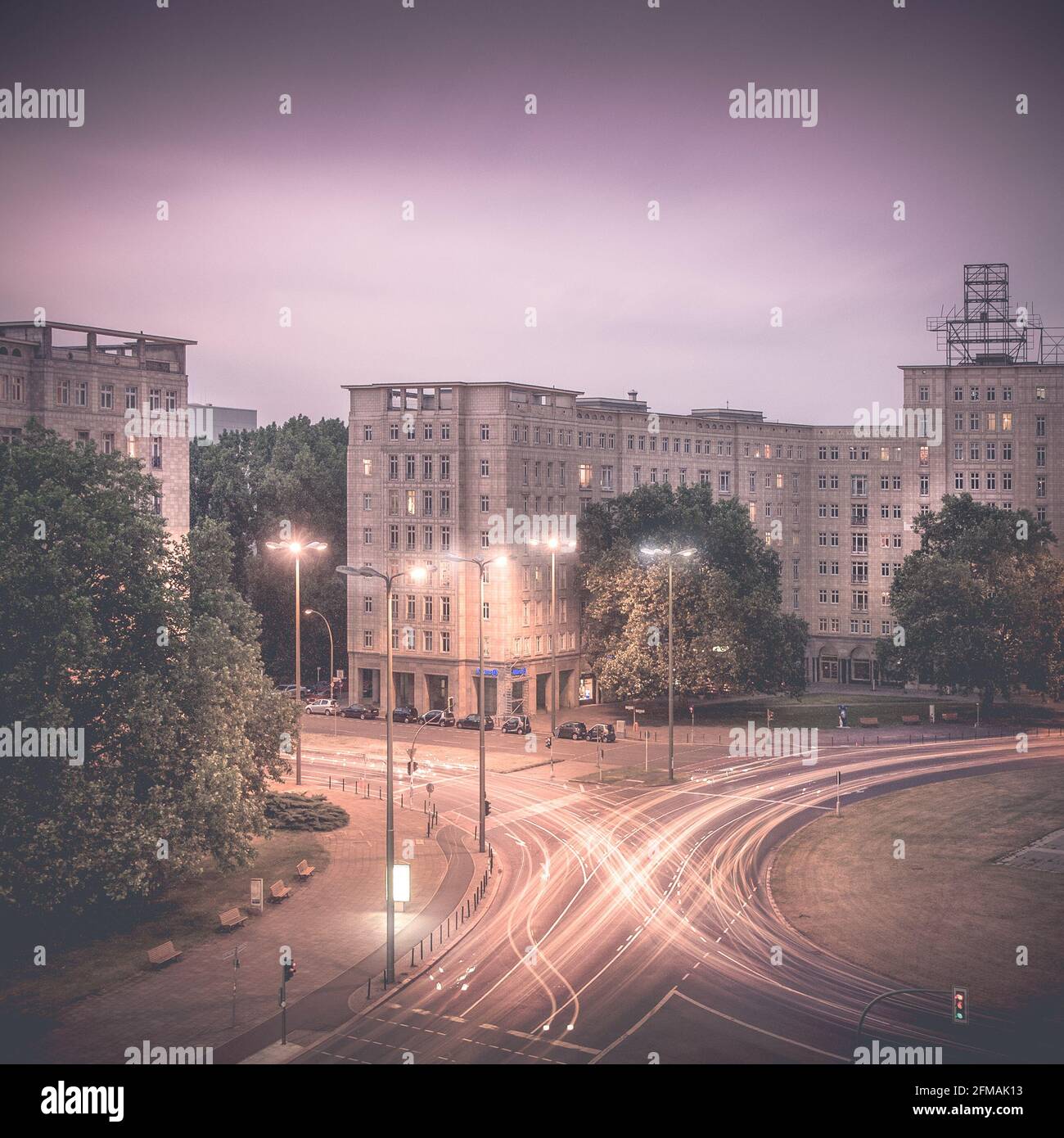 Light trails of the road traffic on Berlin's Strausberger Platz at night. Stock Photo