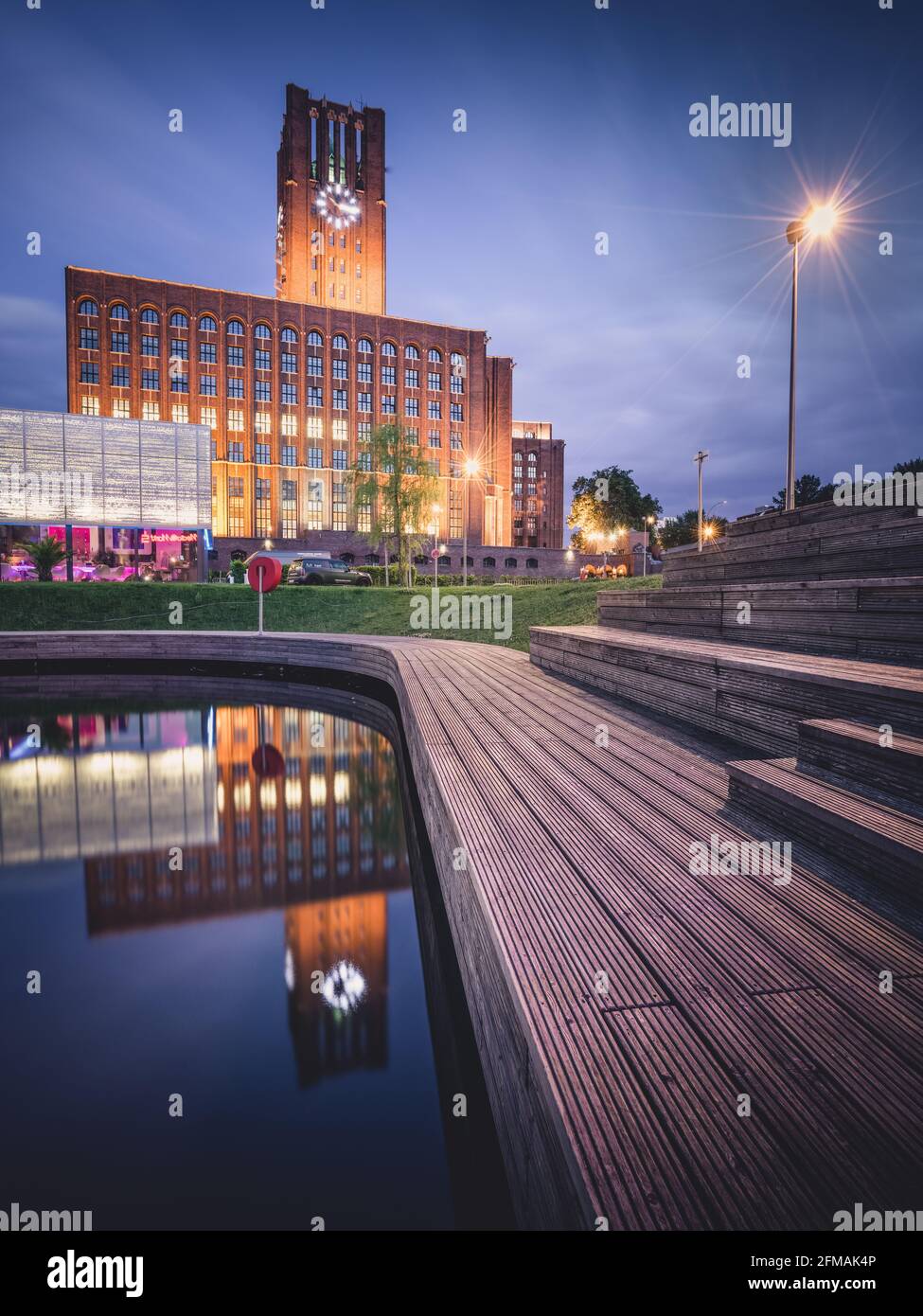 Blue hour at the illuminated Ullsteinhaus in Berlin with reflection in the Tempelhof harbor. Stock Photo