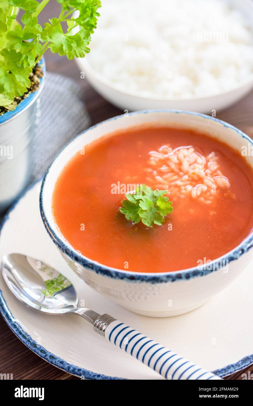 Bright, clean close-up of a bowl of tomato soup with rice, happy, spring colors Stock Photo