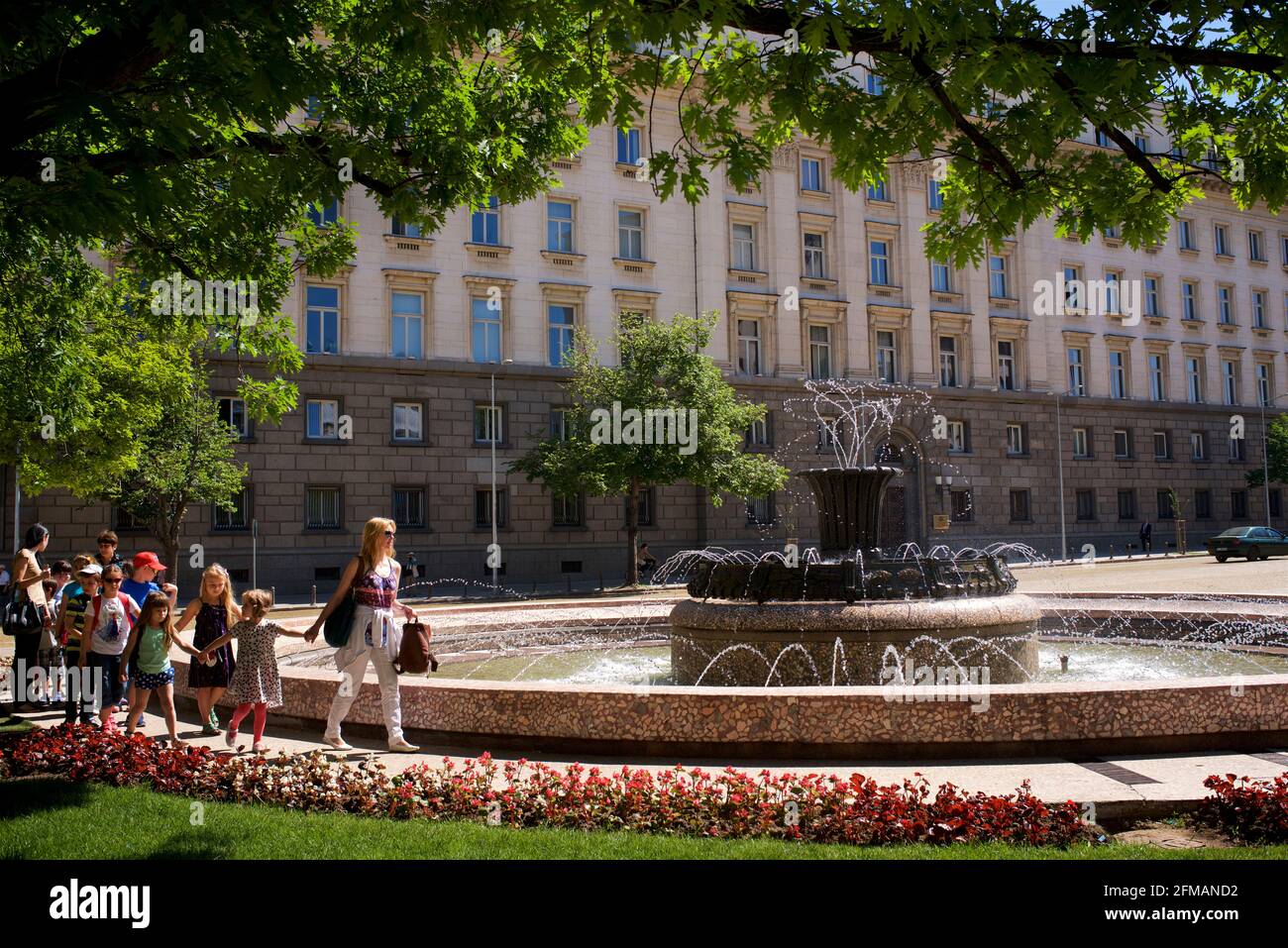 Bulgarian schoolchildren waking past a fountain in Atanas-Burov Plaza,  besides the Presidential Palace  in Sofia, Bulgaria Stock Photo