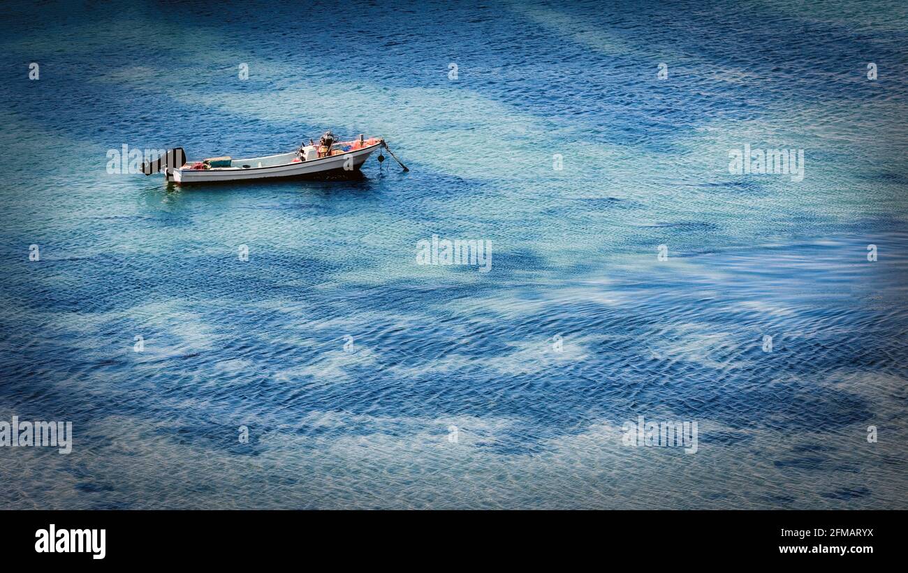 A fishing boat sits alone anchored in the fishing harbor of Hashirimizu near Yokosuka, Japan. Stock Photo