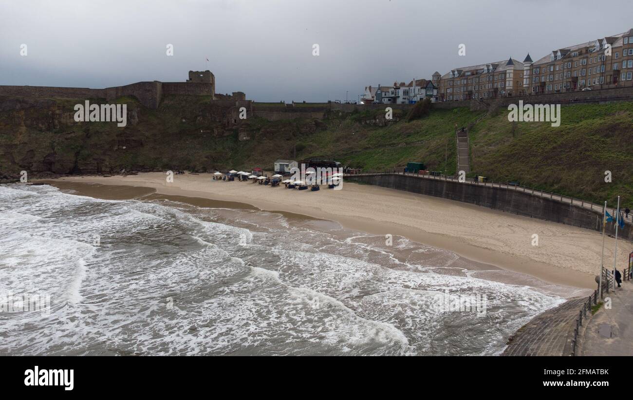Aerial view of Rileys Fish Shack on King Edwards Bay, Tynemouth. The tide is in and there are tables on the beach sheltered under umbrellas. Stock Photo
