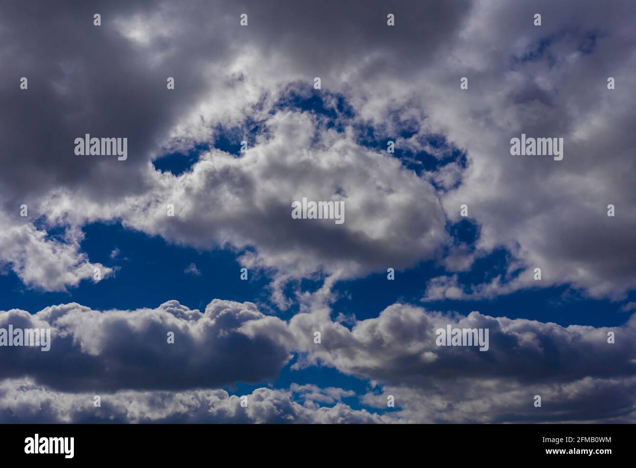 Large rain clouds in the sky in spring, Blue sky between the clouds ...