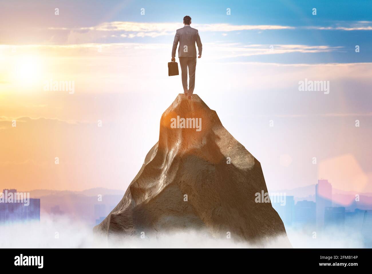 Businessman at the top of mountain in the career concept Stock Photo ...