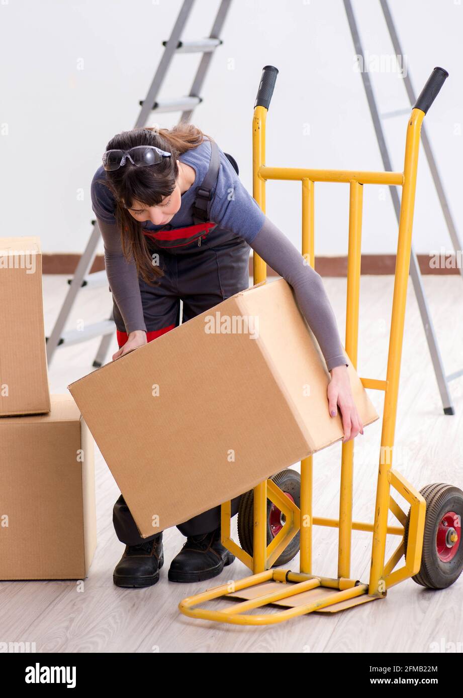 The woman contractor moving boxes in relocation concept Stock Photo - Alamy