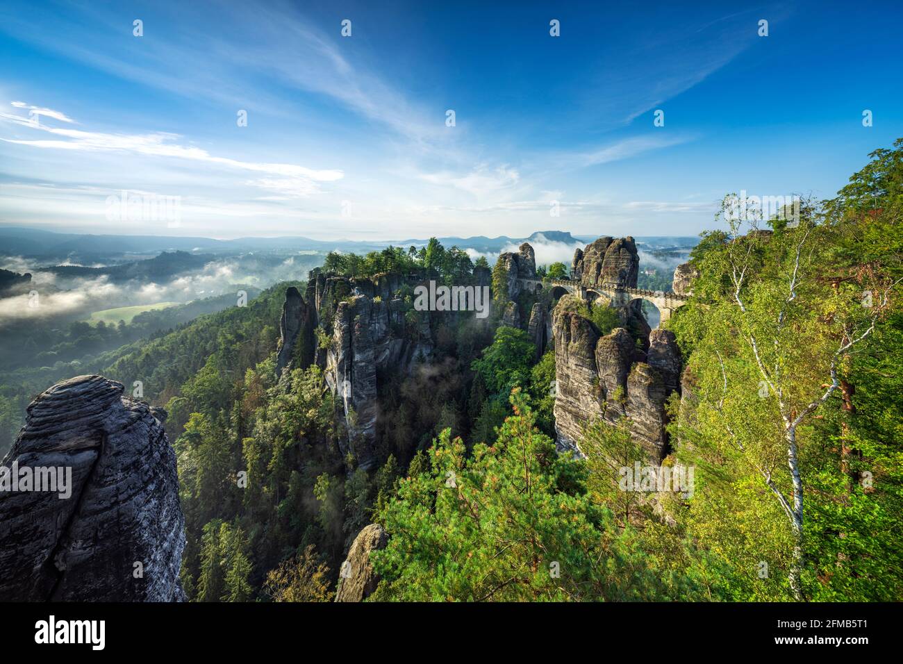 Germany, Saxony, Saxon Switzerland National Park, Elbe Sandstone Mountains, view of the Bastei bridge in the morning, fog in the Elbe valley, behind the Lilienstein Stock Photo
