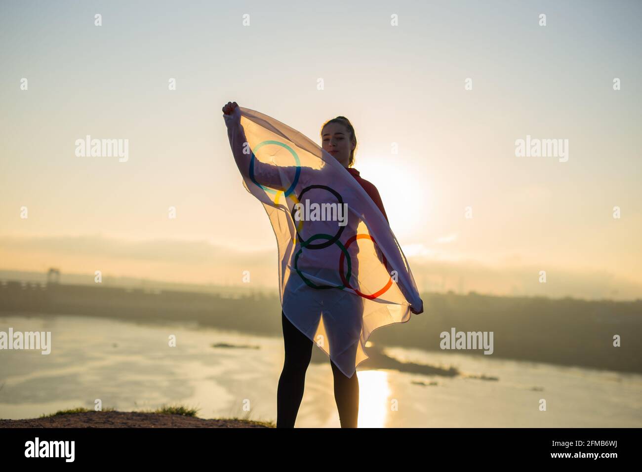 Woman with flag doing martial arts exercises at sunset light Stock Photo