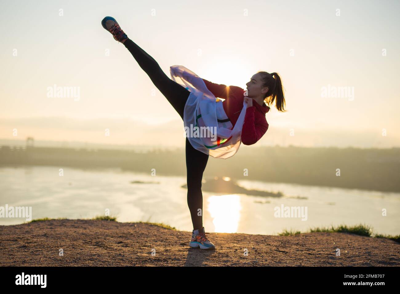 Woman with flag doing martial arts exercises at sunset light Stock Photo