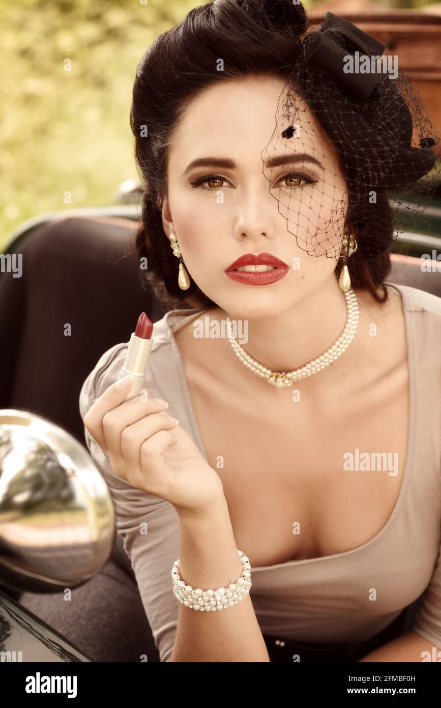 Young 1940s style woman with vintage British racing green and lipstick Stock Photo