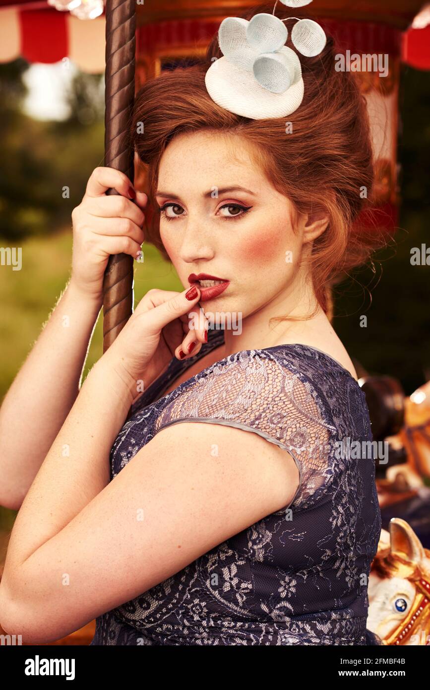 Young woman with red hair and freckles on a nostalgic carousel Stock Photo