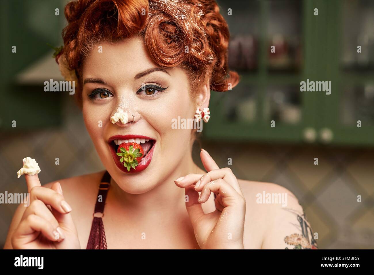 Pinup girl with red hair baking in the kitchen Stock Photo Alamy