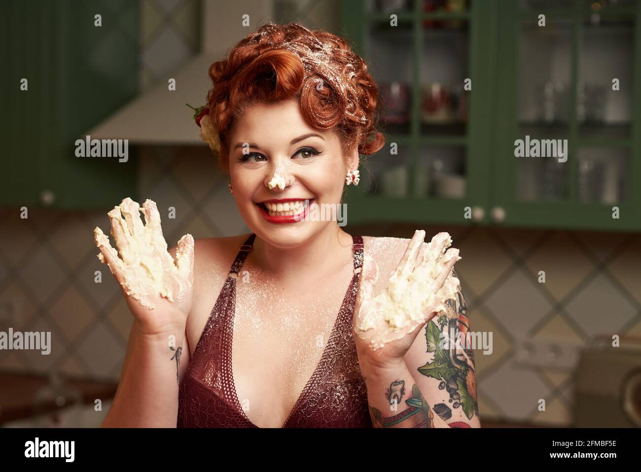 Pin-up girl with red hair baking in the kitchen Stock Photo