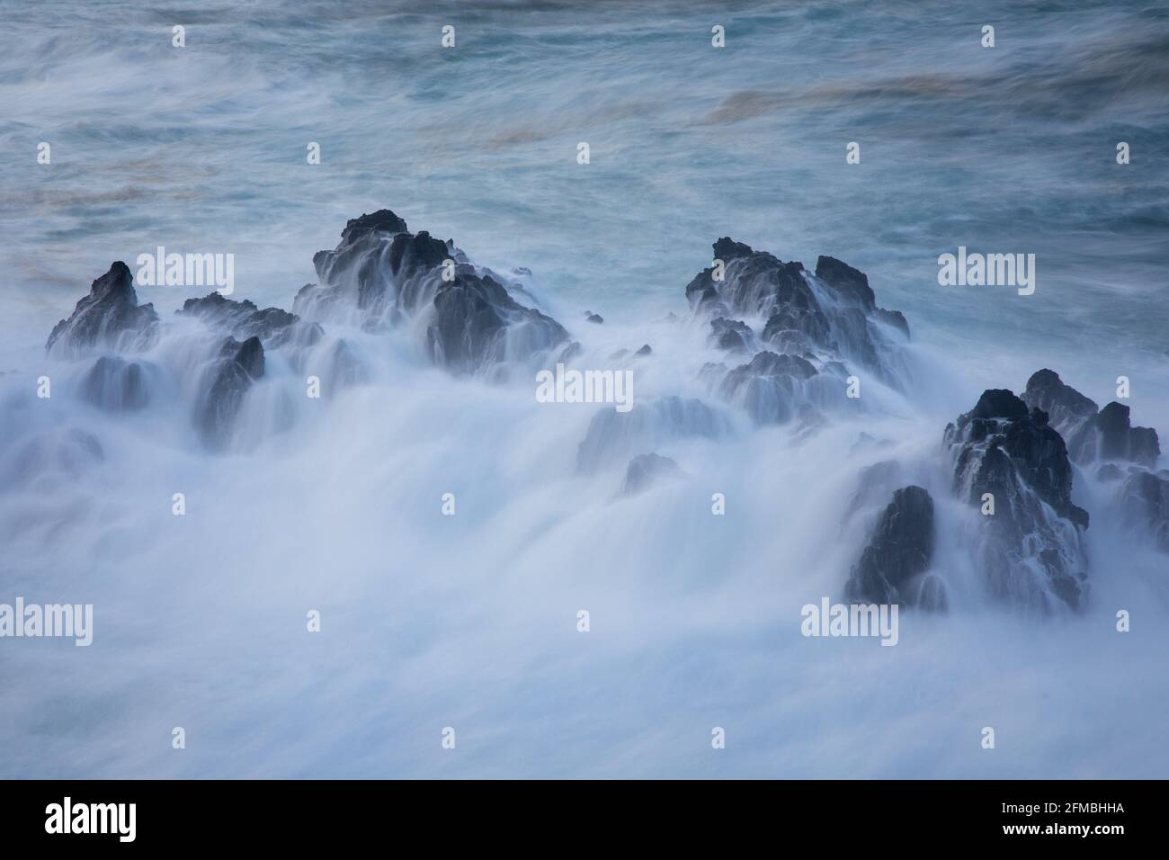 A wave breaks over the rocks near Porto Moniz. Stock Photo